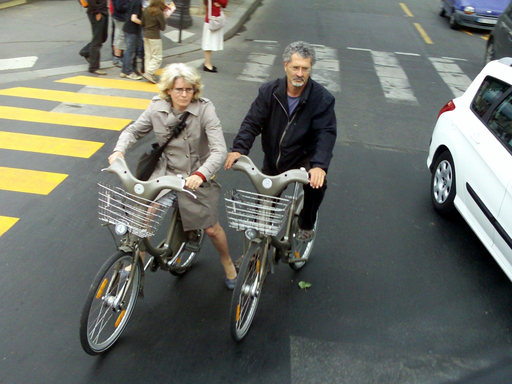 Couple on City Bikes in downtown Paris traffic